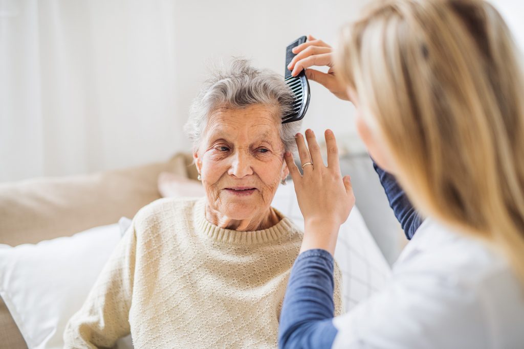 Pflegekraft bürstet Seniorin im Lina-Oberbäumer-Haus liebevoll die Haare.